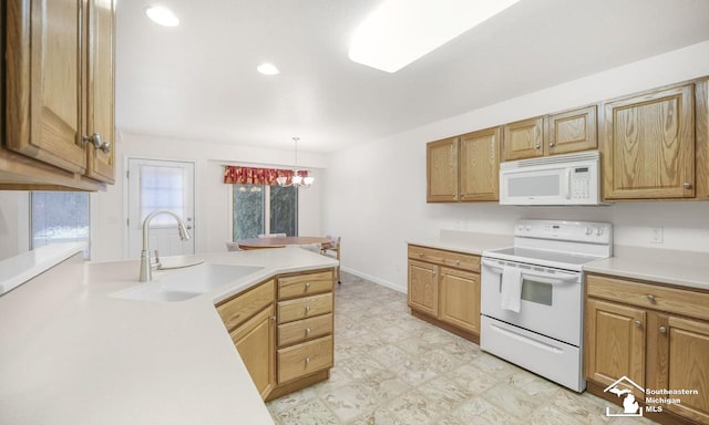 kitchen featuring white appliances, a sink, baseboards, light countertops, and decorative light fixtures