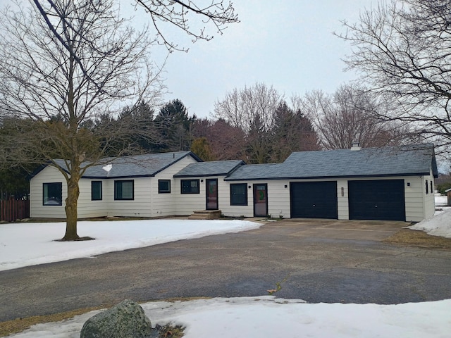 single story home featuring aphalt driveway, roof with shingles, and an attached garage