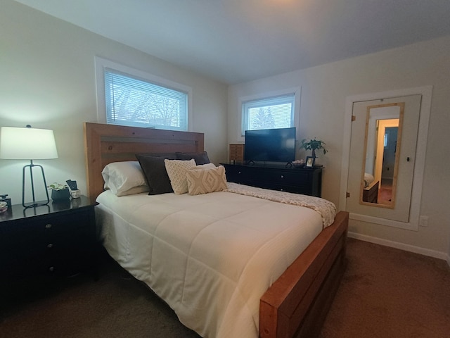 bedroom with baseboards and dark carpet