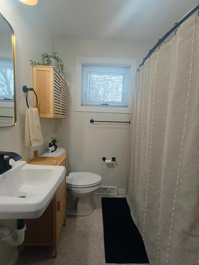 full bathroom featuring a healthy amount of sunlight, visible vents, toilet, and tile patterned floors