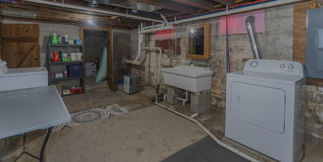 unfinished basement with electric panel, a sink, and washing machine and clothes dryer