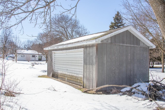 snow covered garage featuring a garage