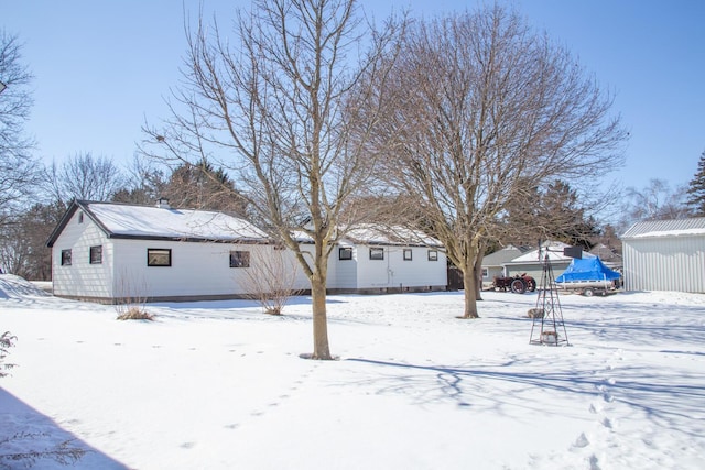 yard layered in snow with an outdoor structure