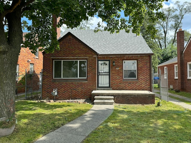 bungalow-style house featuring a front yard, brick siding, fence, and roof with shingles