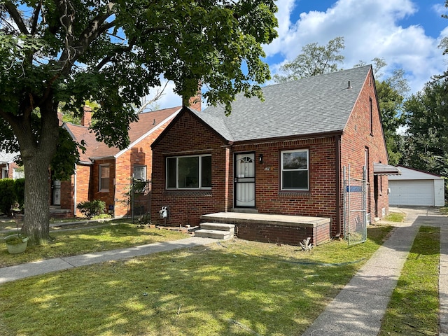 bungalow-style house featuring a garage, brick siding, a shingled roof, an outdoor structure, and a front lawn