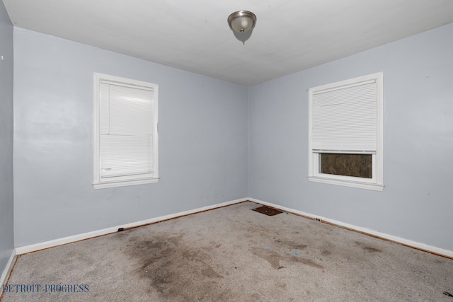 carpeted spare room featuring baseboards