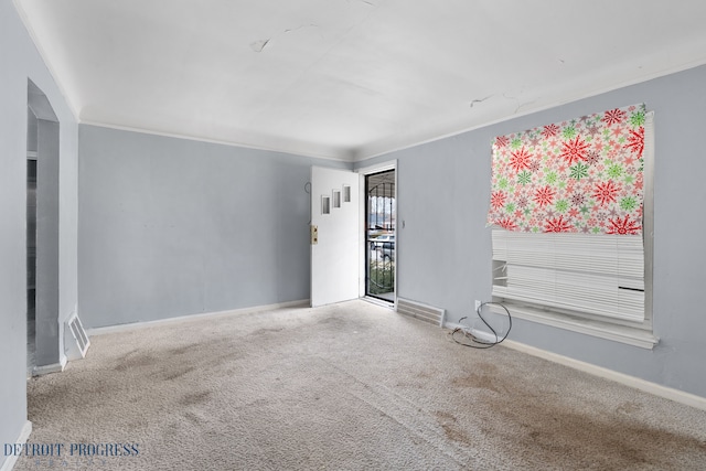 empty room featuring carpet floors, baseboards, visible vents, and ornamental molding