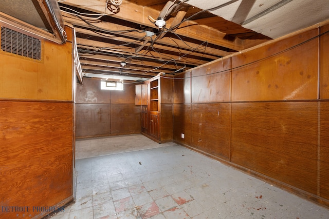 basement featuring wooden walls