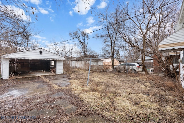 view of yard with an outbuilding, a detached garage, and fence