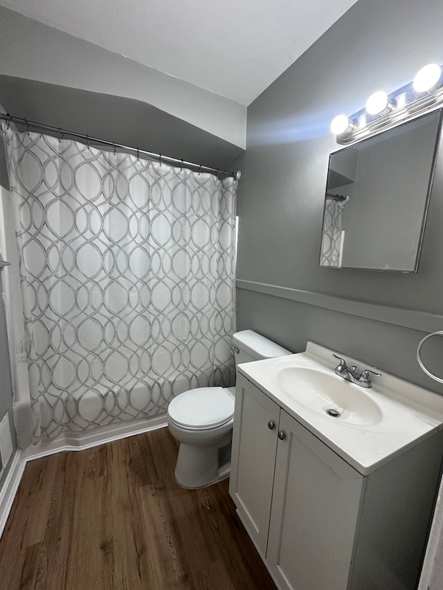 full bath featuring vanity, wood finished floors, toilet, and shower / tub combo with curtain