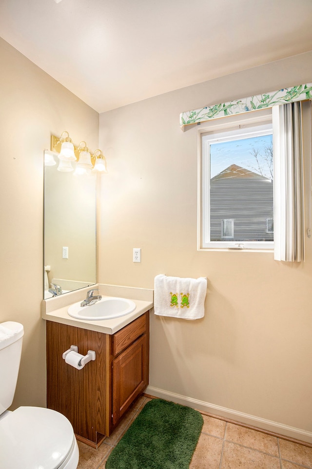 bathroom featuring baseboards, vanity, toilet, and tile patterned floors