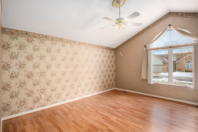 bonus room with light wood-type flooring, vaulted ceiling, and wallpapered walls