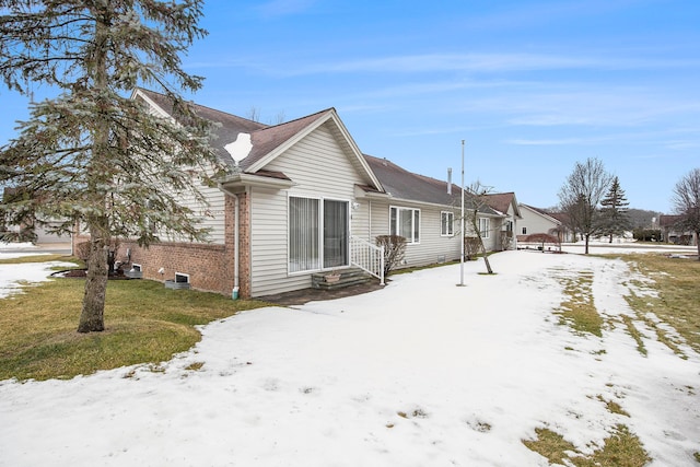 view of snow covered exterior featuring brick siding