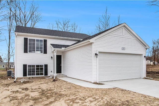 split level home with a garage, central AC unit, and concrete driveway