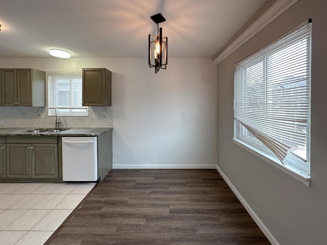 kitchen featuring dishwasher, backsplash, a sink, and baseboards