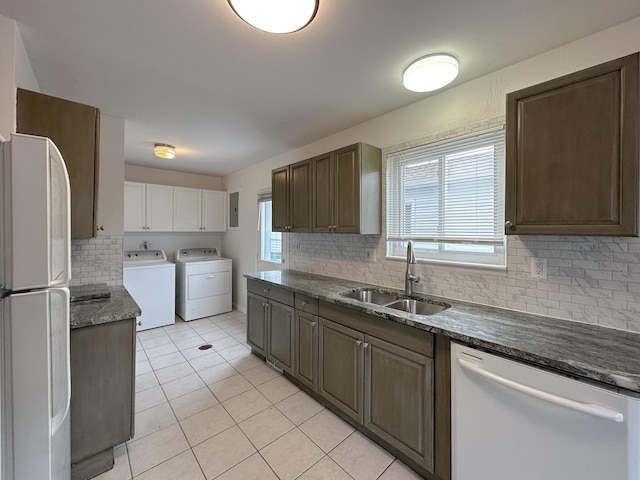 kitchen featuring white appliances, a wealth of natural light, a sink, and independent washer and dryer