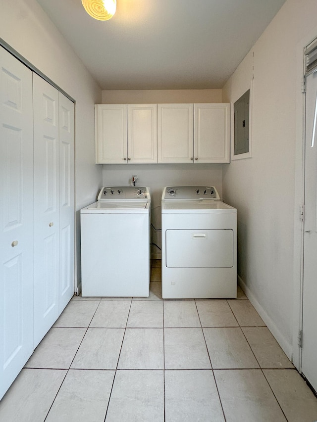 laundry area with light tile patterned floors, baseboards, cabinet space, electric panel, and washer and clothes dryer