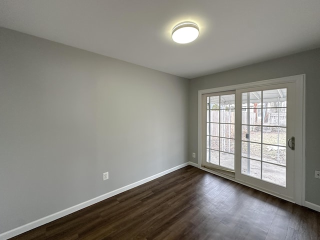 empty room featuring dark wood-style floors and baseboards