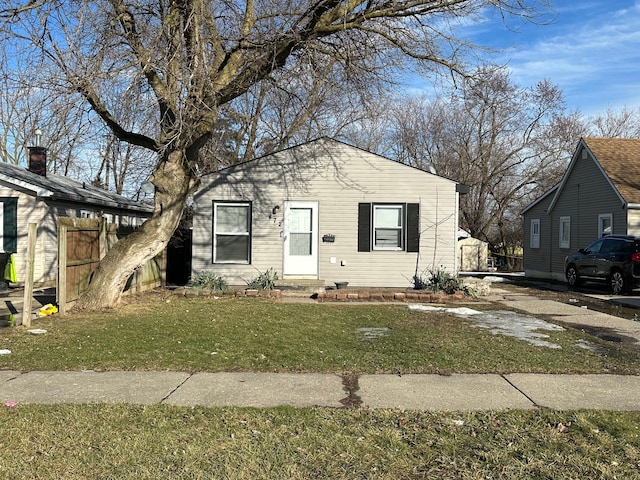 bungalow featuring a front yard and fence