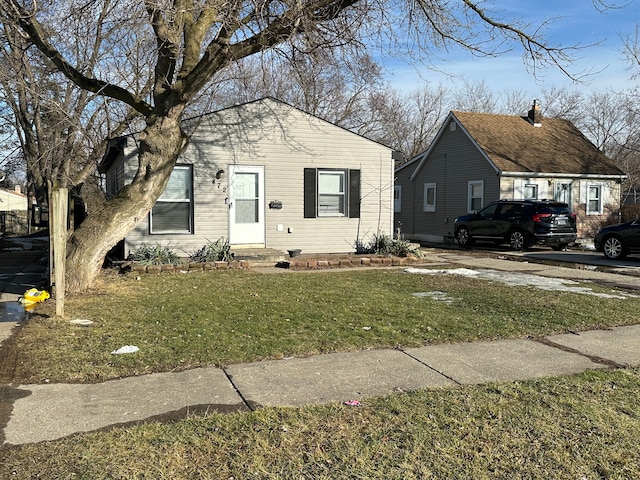 bungalow-style home with entry steps and a front yard