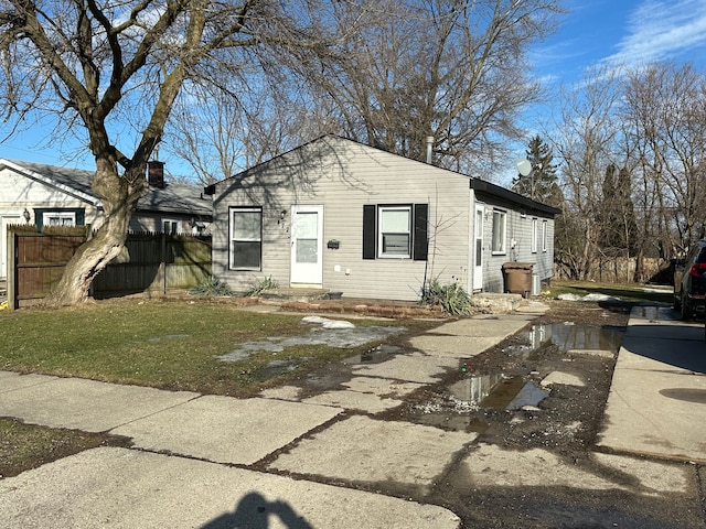 view of front facade featuring a front yard and fence