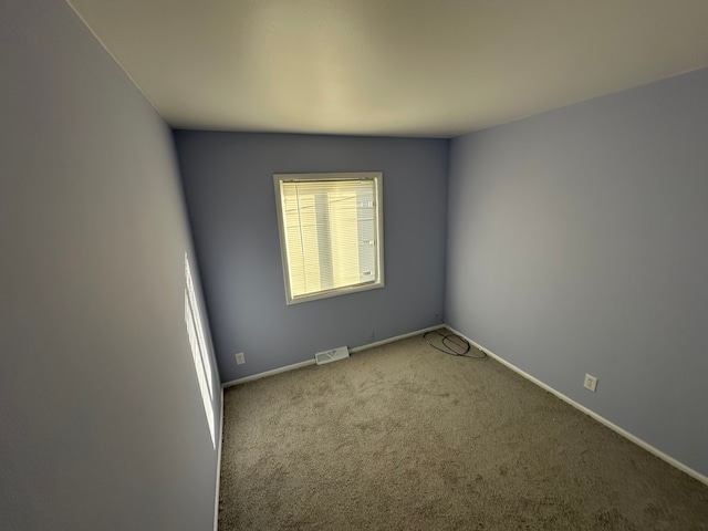 carpeted spare room with baseboards and visible vents