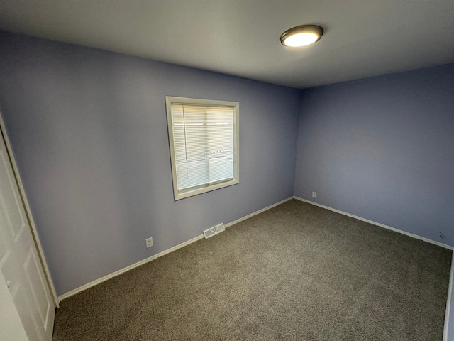 carpeted spare room with visible vents and baseboards