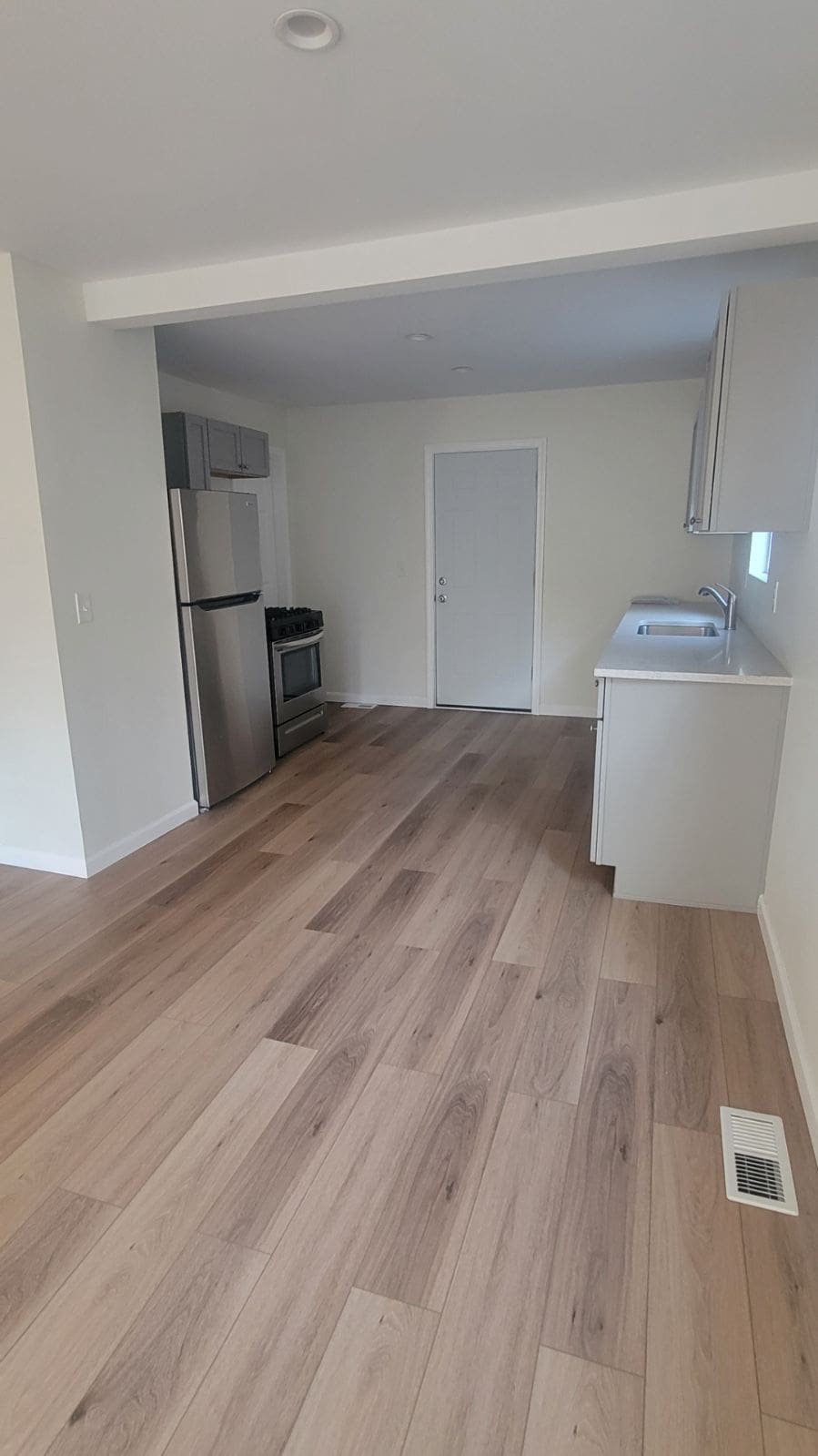 kitchen featuring baseboards, visible vents, light wood-style flooring, appliances with stainless steel finishes, and light countertops