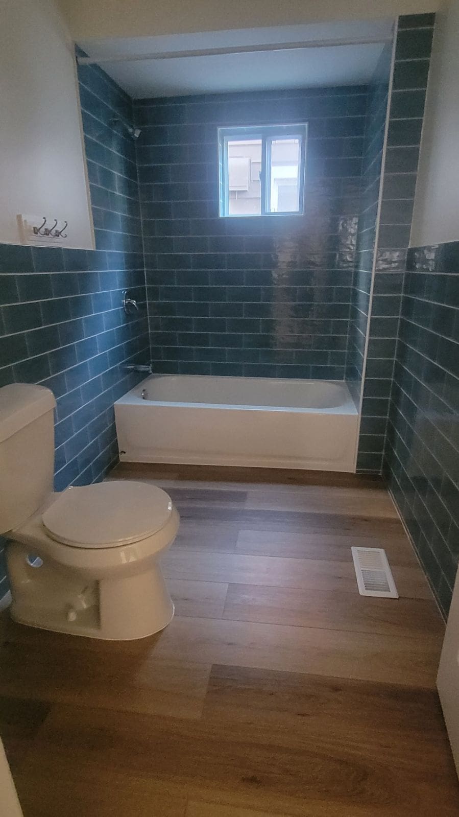 bathroom featuring visible vents, shower / bathing tub combination, tile walls, and toilet