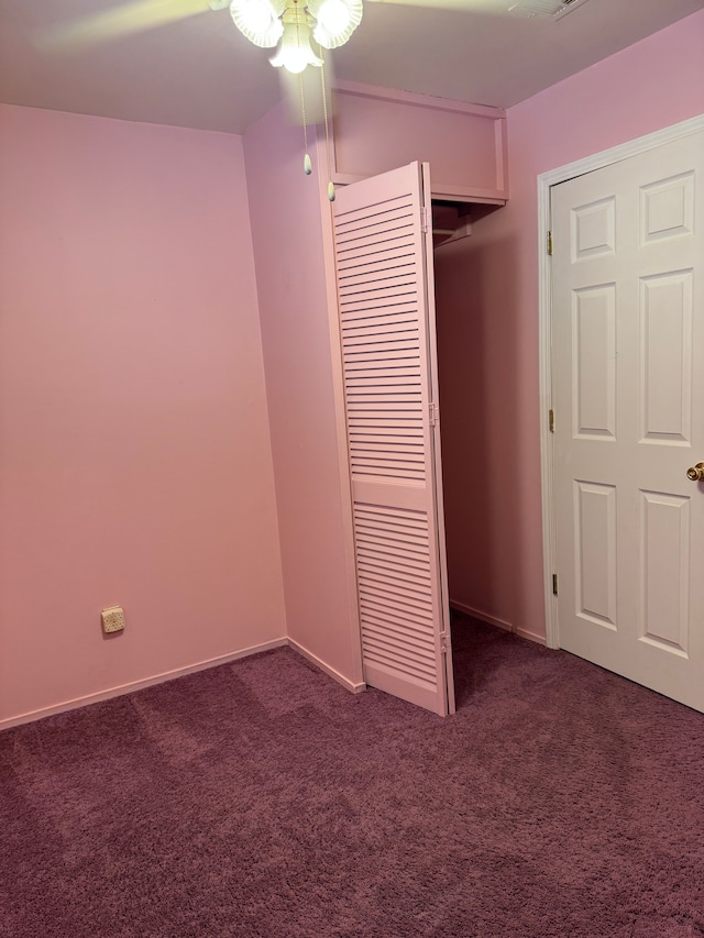 unfurnished bedroom featuring a ceiling fan, a closet, dark carpet, and baseboards