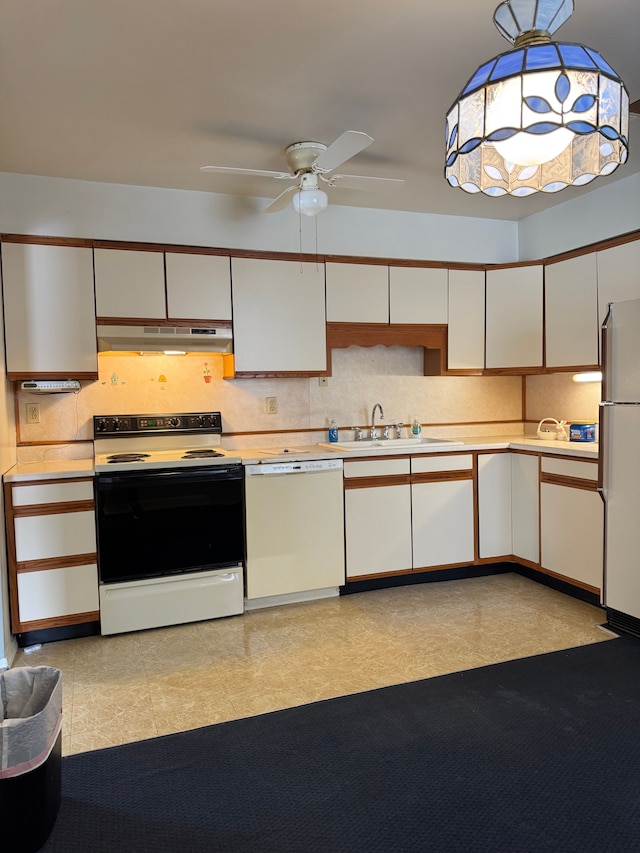 kitchen featuring light countertops, white appliances, a sink, and under cabinet range hood