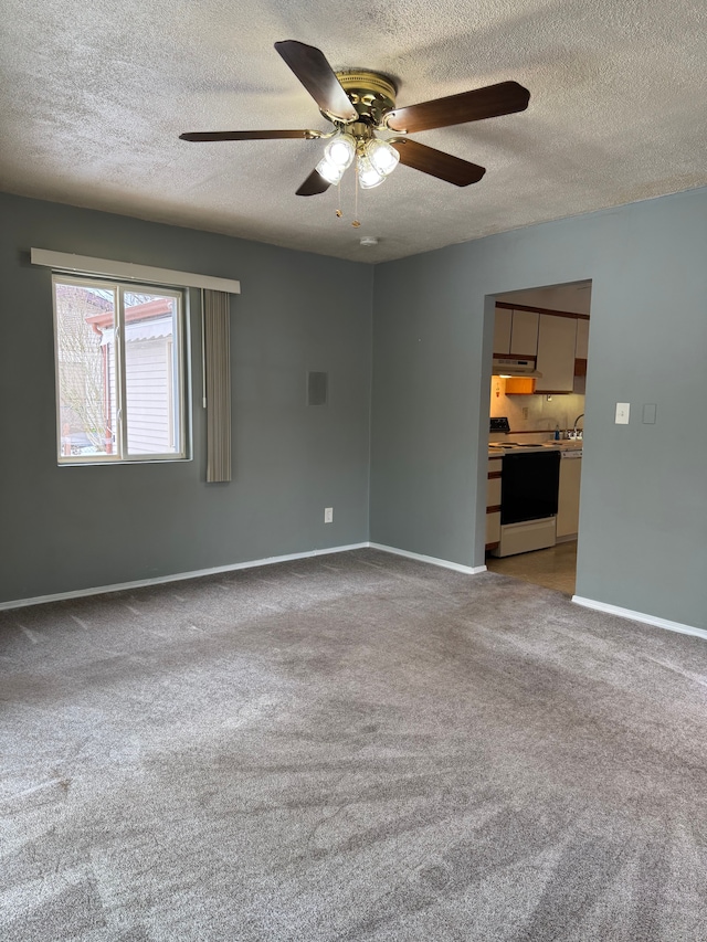 carpeted empty room featuring a ceiling fan, a textured ceiling, and baseboards