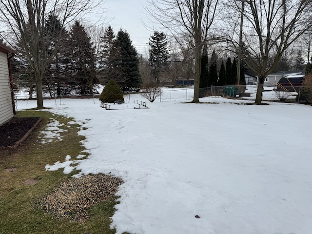 yard layered in snow featuring fence