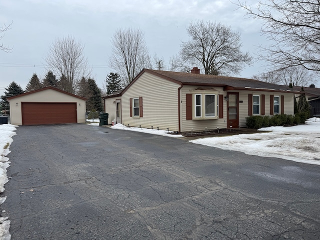 view of front of property with an outbuilding, a detached garage, and a chimney