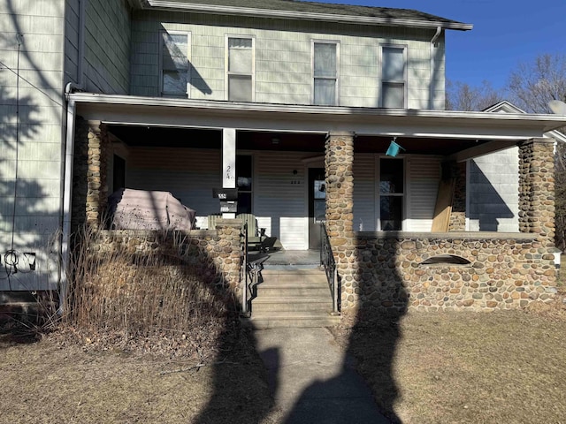 exterior space with covered porch and stone siding