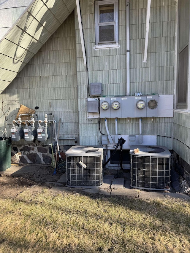 exterior details with gas meter, electric meter, and central AC unit