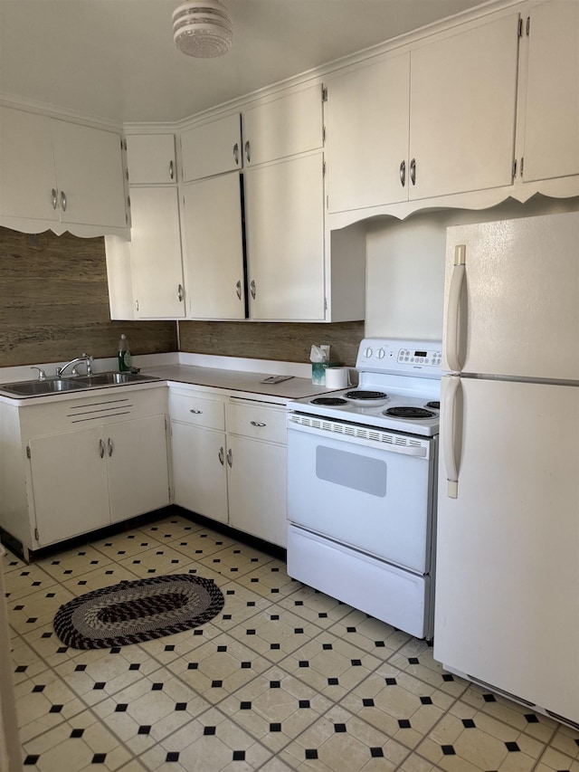 kitchen featuring light floors, white appliances, a sink, and white cabinets