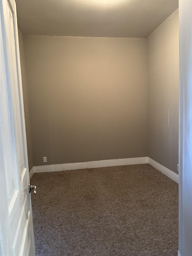 carpeted spare room featuring baseboards