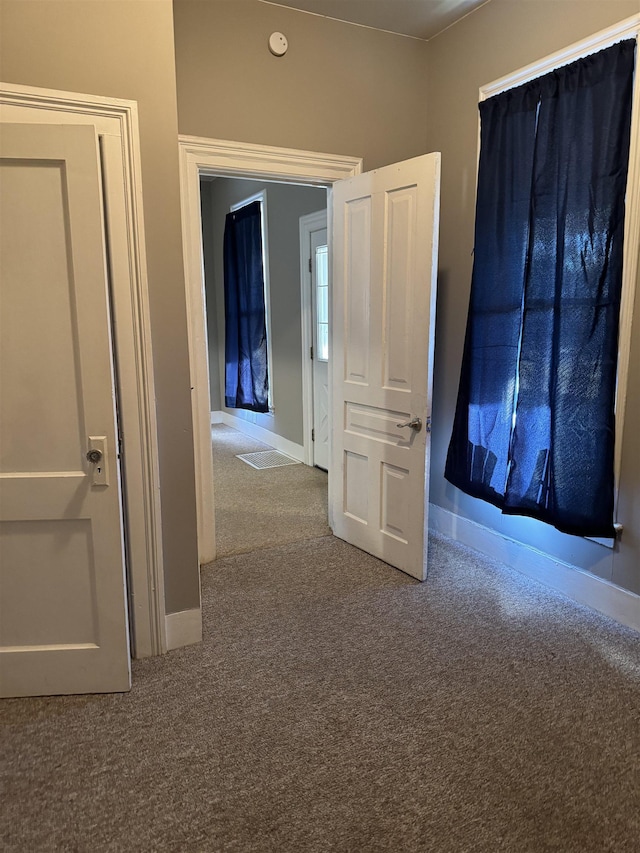 hallway with carpet flooring and baseboards