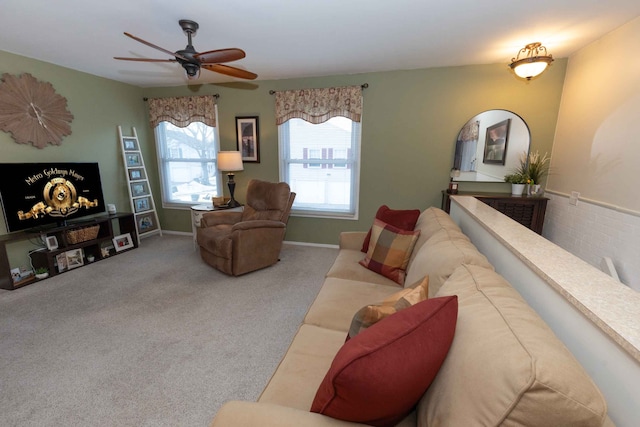 carpeted living room featuring a ceiling fan and baseboards