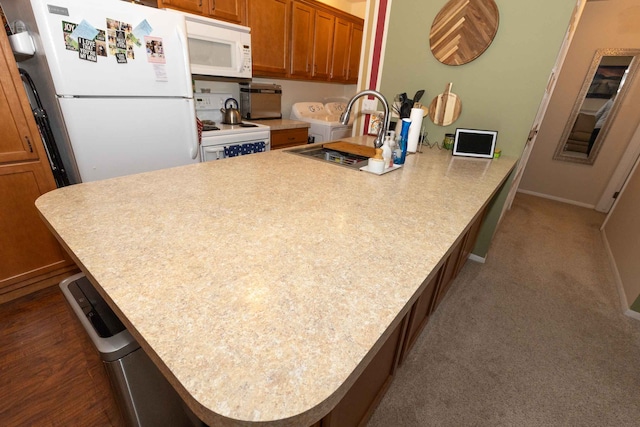 kitchen with white appliances, baseboards, brown cabinetry, light countertops, and a sink