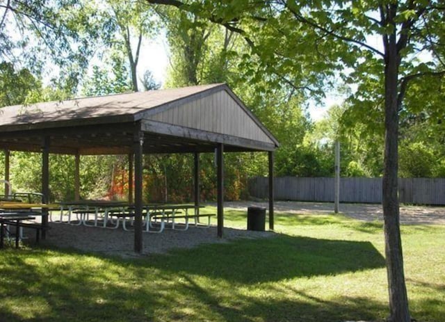 view of property's community with fence and a lawn