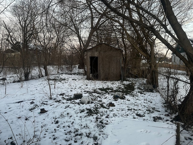 snowy yard with a shed and an outdoor structure