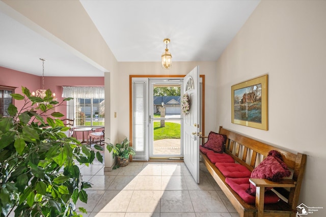 entrance foyer featuring a wealth of natural light, a notable chandelier, and lofted ceiling