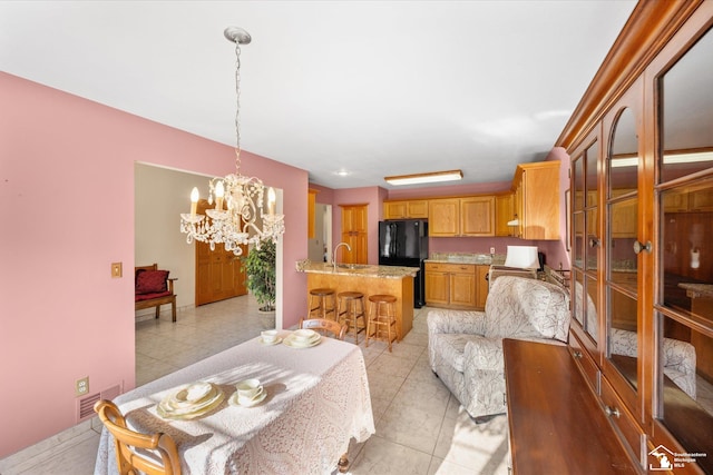 dining area featuring light tile patterned floors, visible vents, and an inviting chandelier