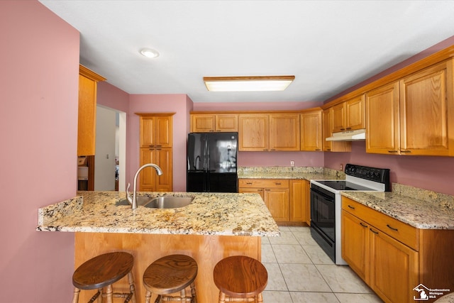 kitchen with a breakfast bar area, a peninsula, electric range, a sink, and freestanding refrigerator