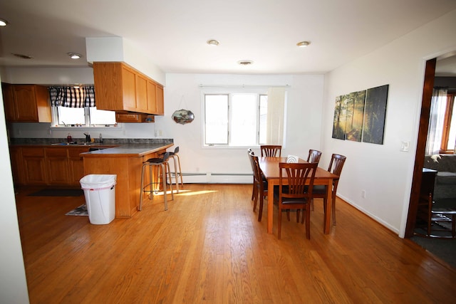 dining room featuring baseboards, baseboard heating, visible vents, and light wood-style floors