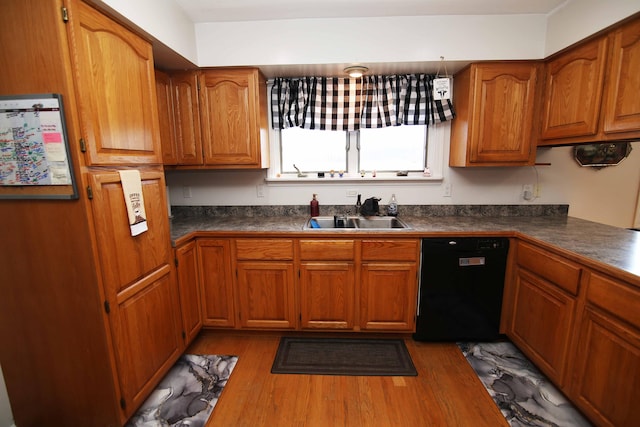 kitchen featuring a sink, brown cabinetry, dishwasher, and wood finished floors