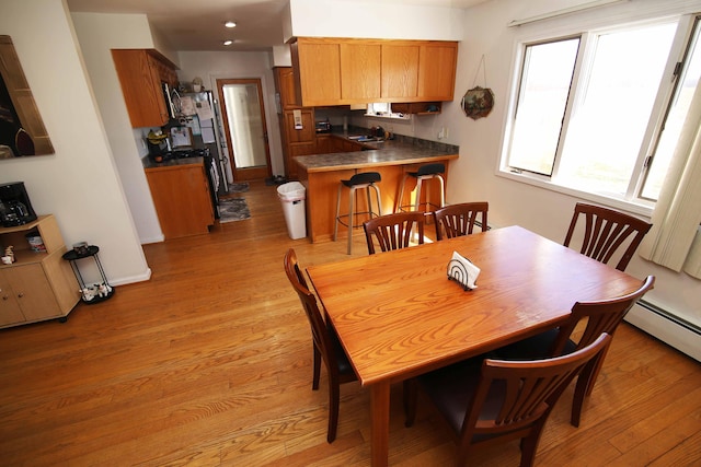 dining room featuring light wood-type flooring and baseboards