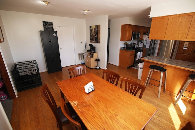 dining space with visible vents and light wood-style flooring